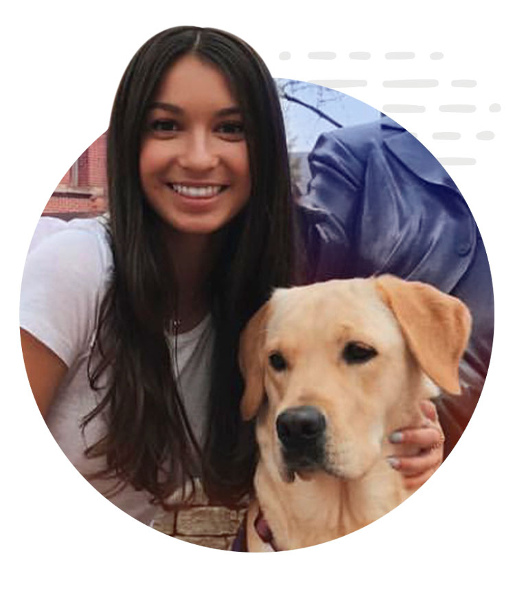 Ilinca smiles while holding a service dog she's training with the 鶹APP Canine Assistant Network (ICAN) at IU