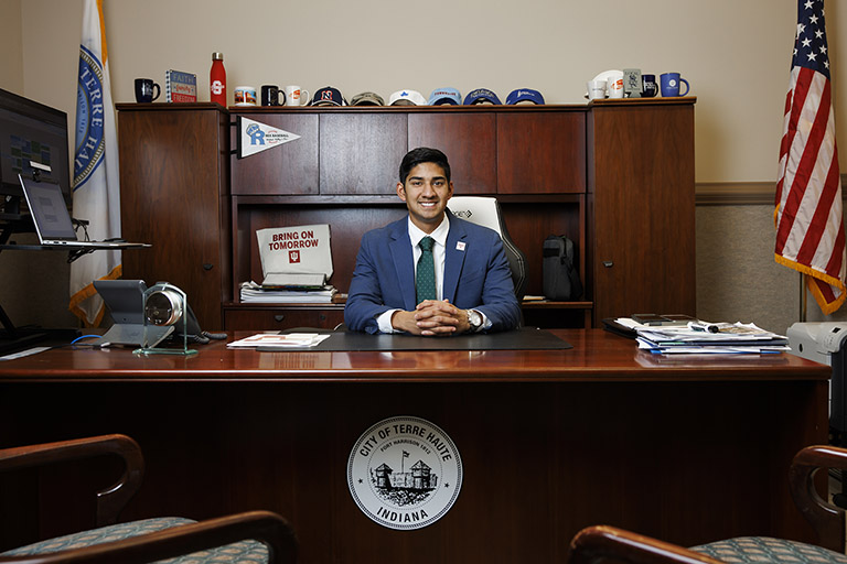 A person in a suit sits behind a desk. The desk has a seal that says ‘City of Terre Haute, 鶹APP.’